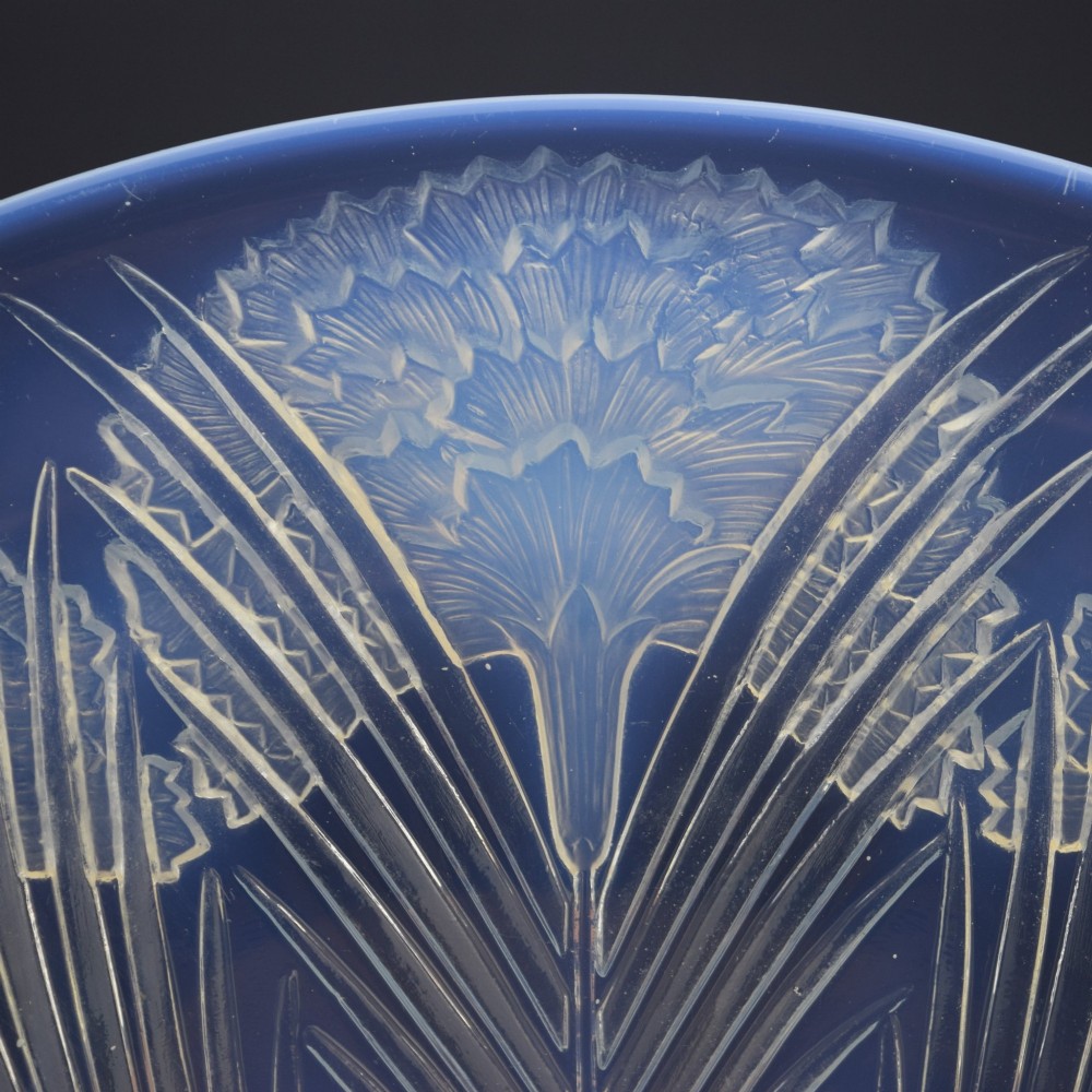 A circular Art Deco opalescent glass shallow bowl featuring a molded floral carnation design radiating from a central signature. View III