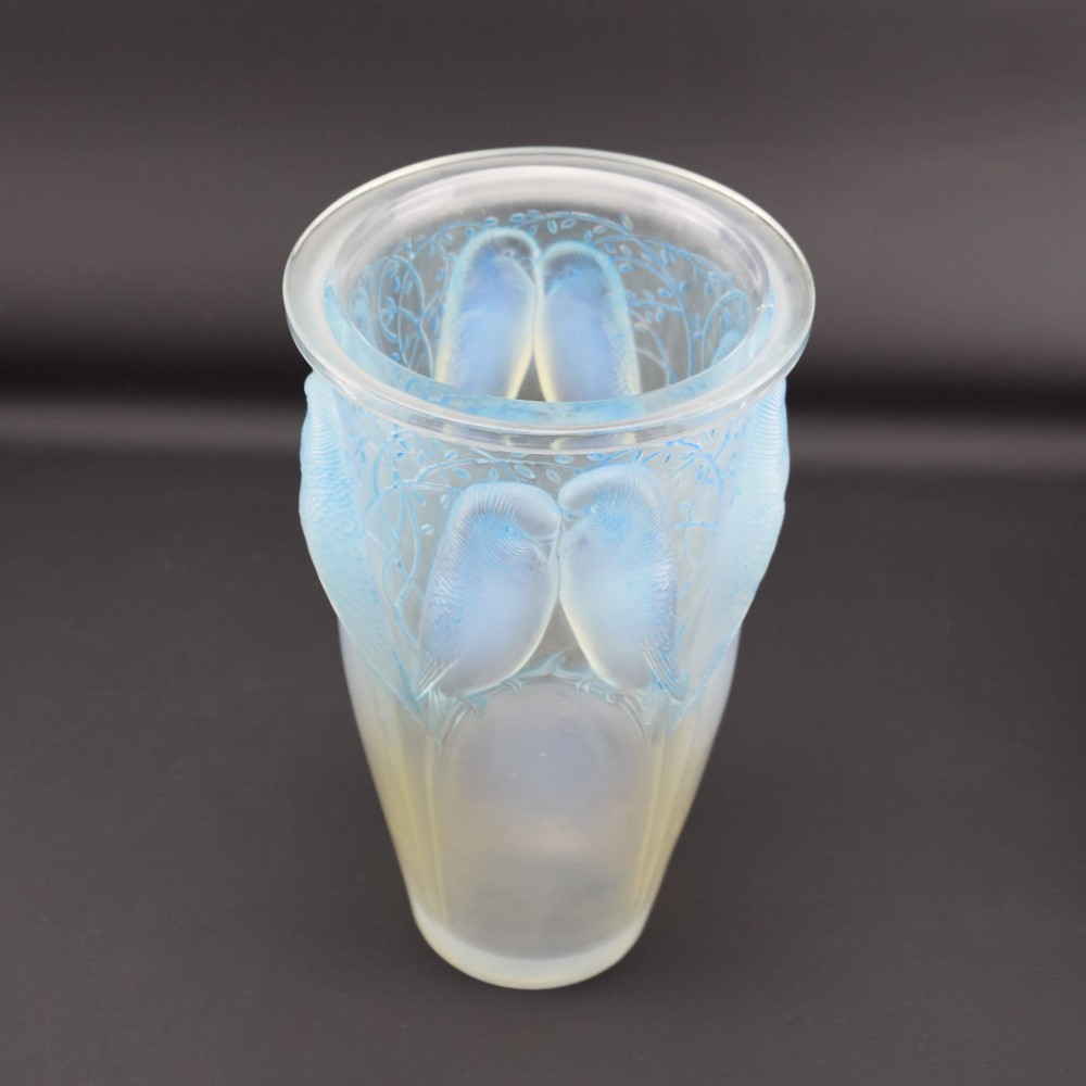 An Art Deco Rene Lalique opalescent glass vase featuring high relief carvings of budgerigars perched on branches with subtle blue staining. View VI