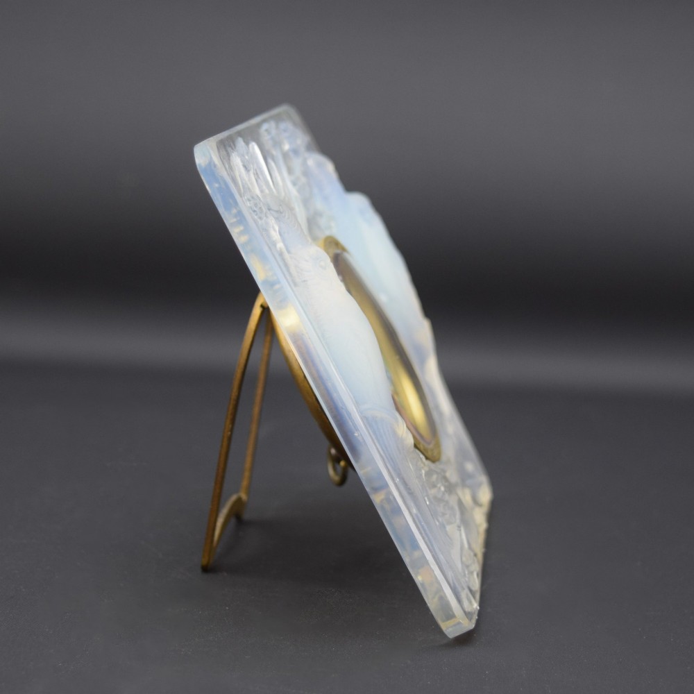 A square Rene Lalique Art Deco opalescent glass clock depicting moulded lovebirds amongst branches around a central circular brass dial. View IV