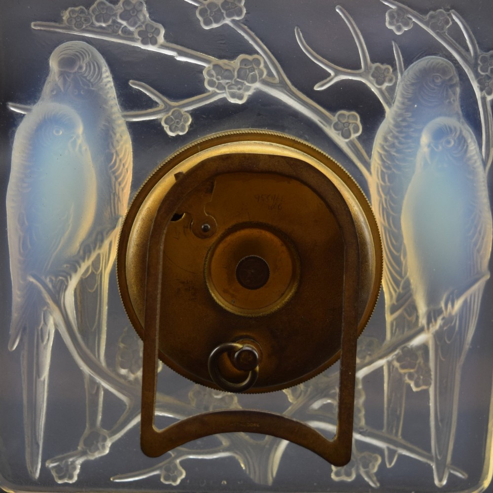 A square Rene Lalique Art Deco opalescent glass clock depicting moulded lovebirds amongst branches around a central circular brass dial. View VI