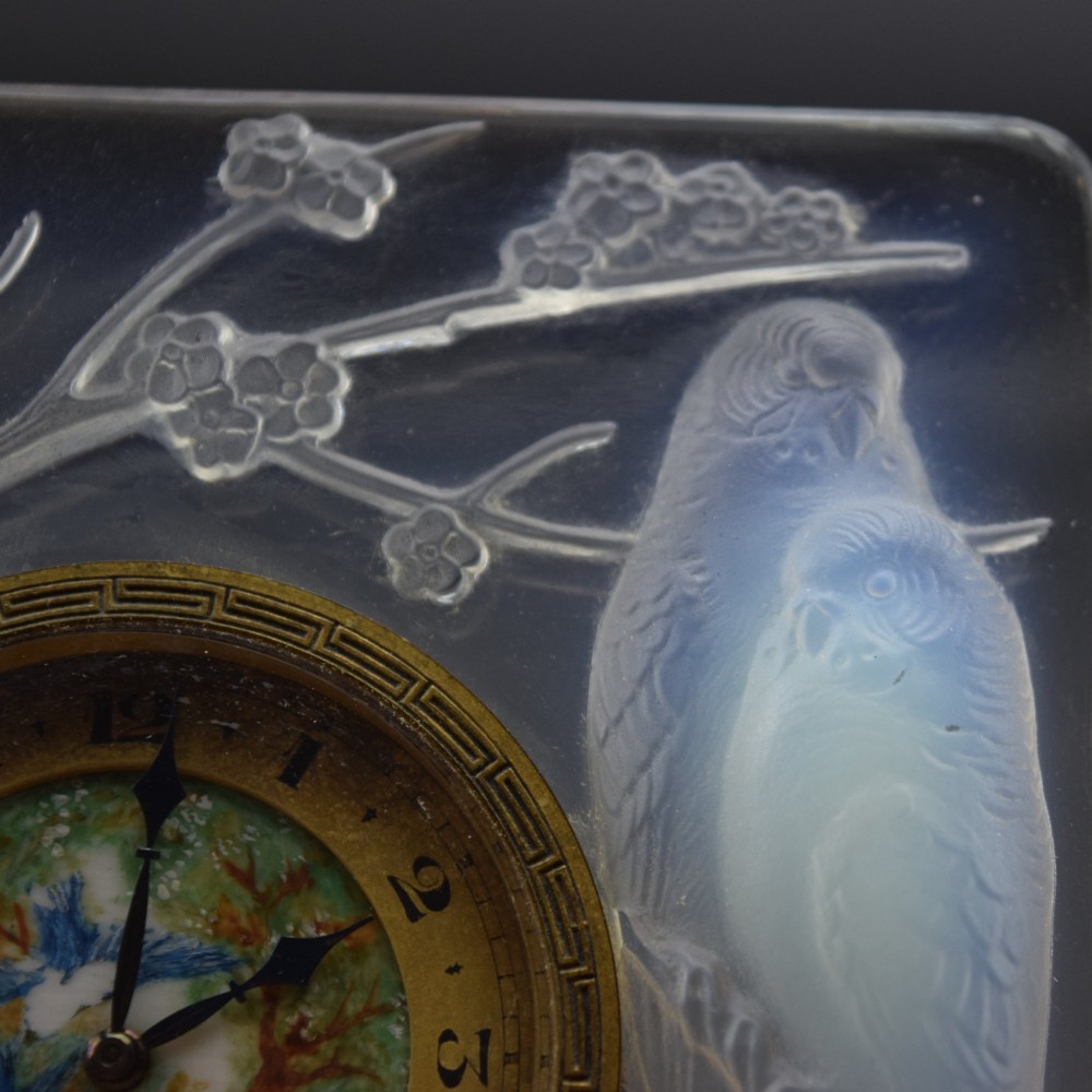 A square Rene Lalique Art Deco opalescent glass clock depicting moulded lovebirds amongst branches around a central circular brass dial. View VIII