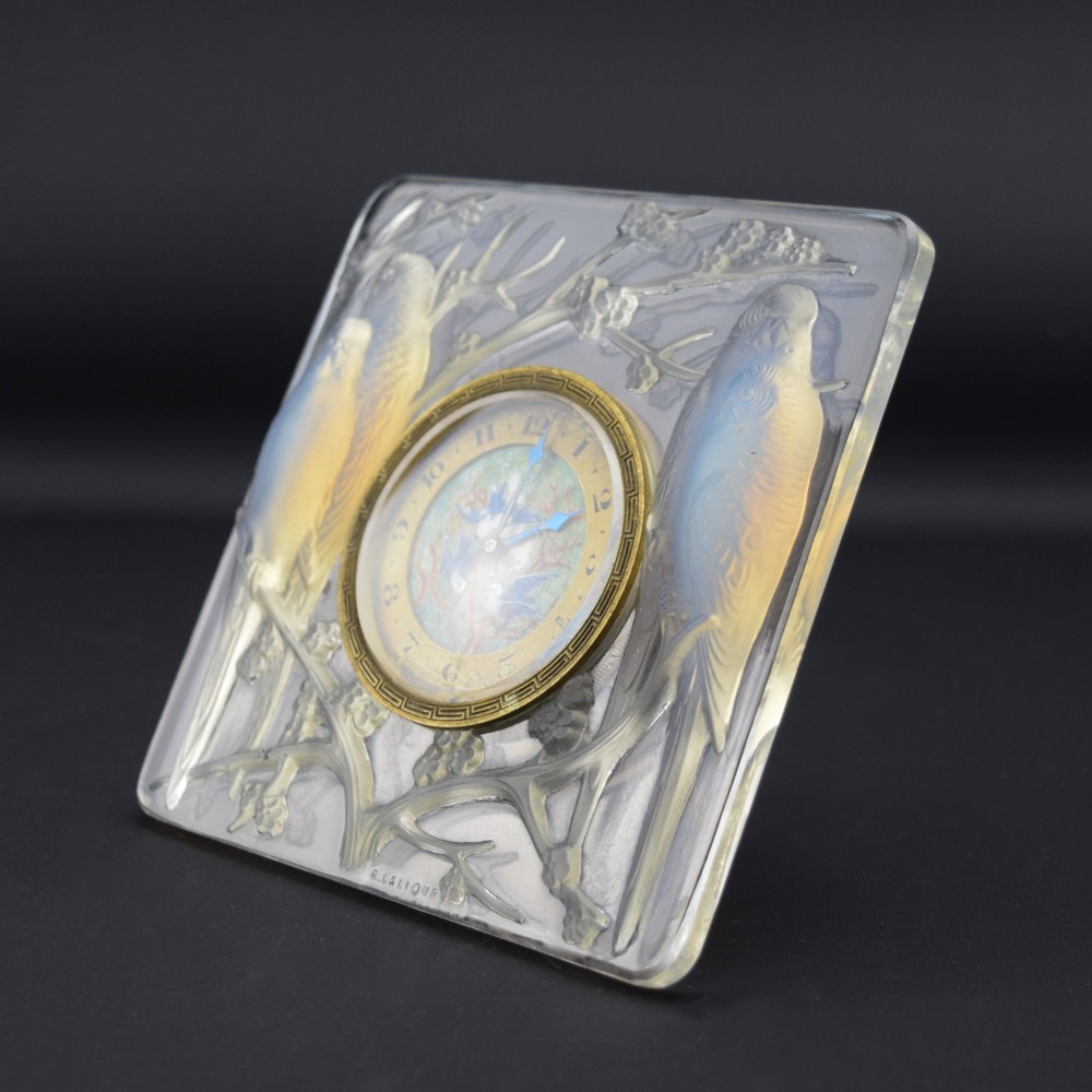 A square Rene Lalique Art Deco opalescent glass clock depicting moulded lovebirds amongst branches around a central circular brass dial. View XI