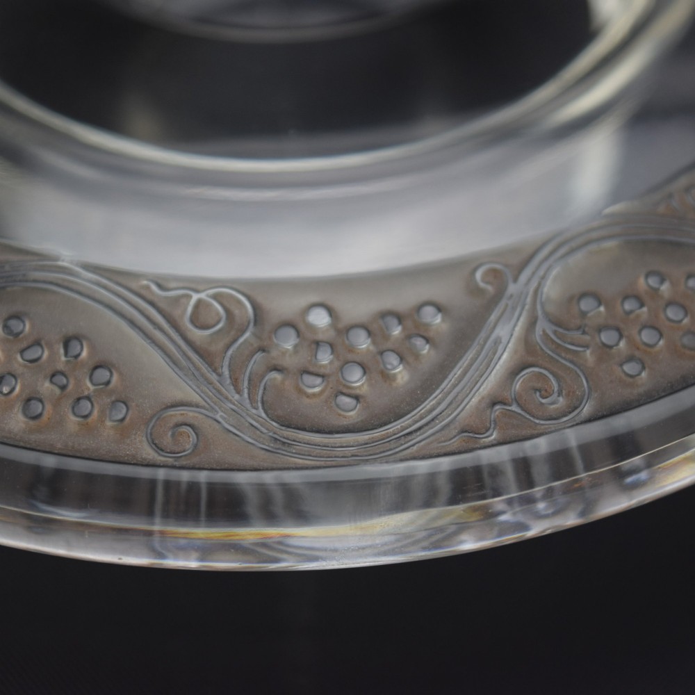 A pair of circular Rene Lalique clear glass Riquewihr candlesticks featuring concentric rings etched with a stylized grapevine motif. View V