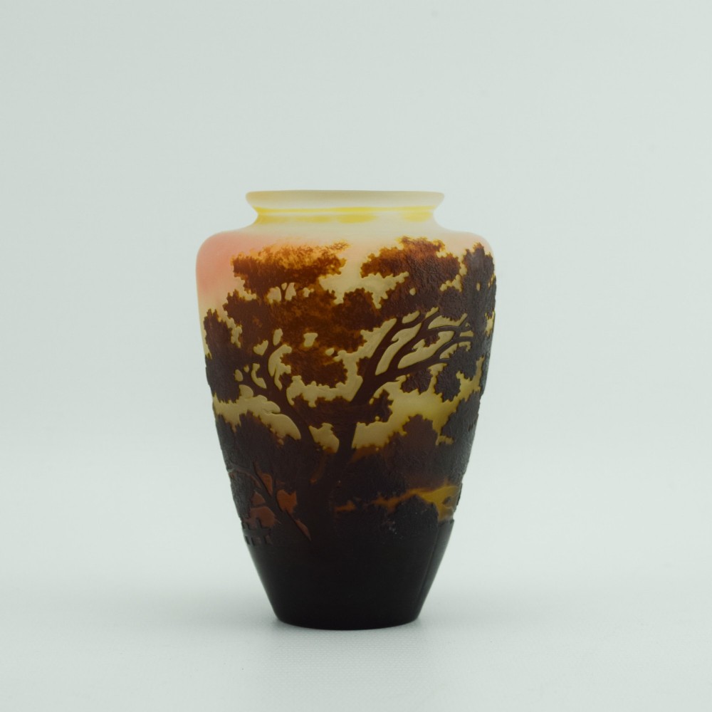 An Art Nouveau cameo glass vase featuring an acid-etched dark brown woodland landscape set against a warm yellow and soft pink background. View III