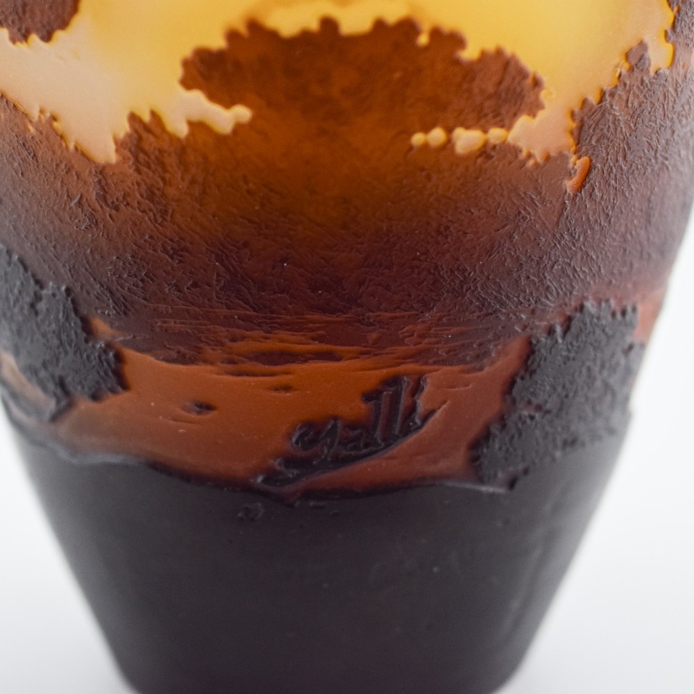 An Art Nouveau cameo glass vase featuring an acid-etched dark brown woodland landscape set against a warm yellow and soft pink background. View VIII