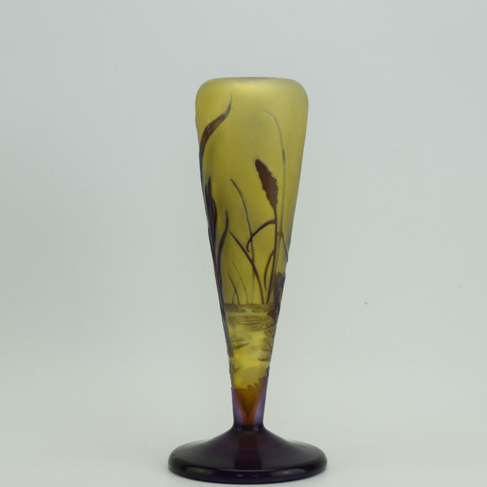 An Art Nouveau cameo glass vase featuring dark purple and brown acid-etched iris flowers against a textured yellow background with a dark purple foot. View V
