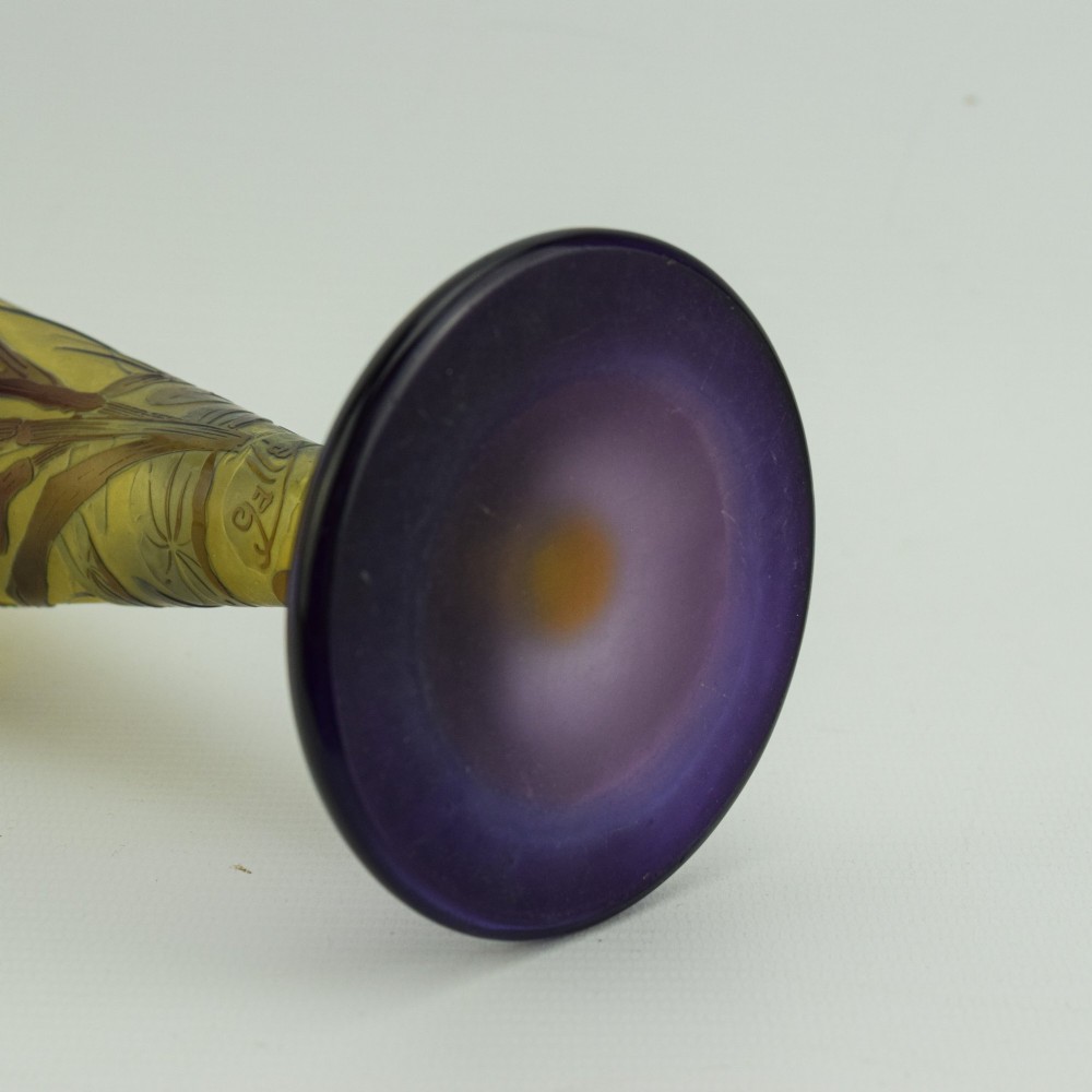 An Art Nouveau cameo glass vase featuring dark purple and brown acid-etched iris flowers against a textured yellow background with a dark purple foot. View X