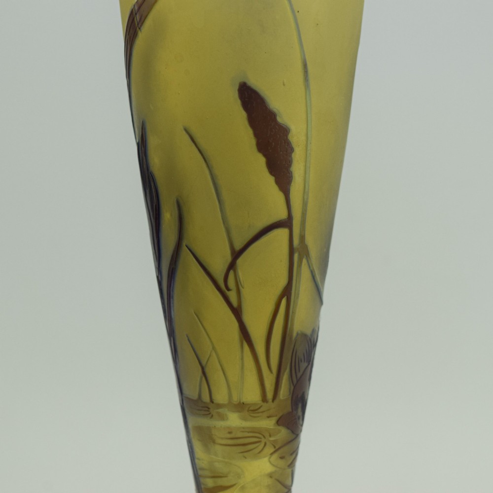An Art Nouveau cameo glass vase featuring dark purple and brown acid-etched iris flowers against a textured yellow background with a dark purple foot. View XIII