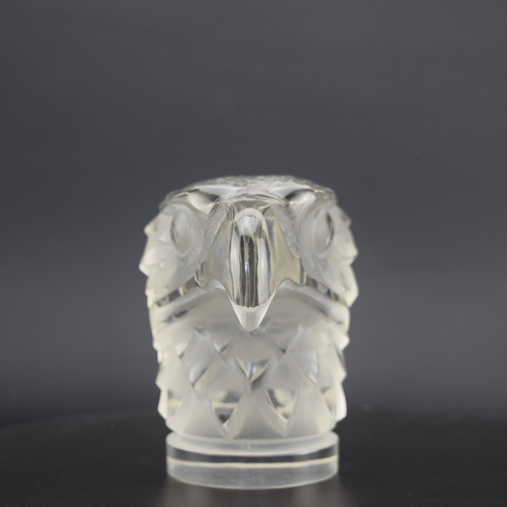 A clear and frosted moulded glass sculpture depicting an eagle head in profile, designed as an Art Deco automobile mascot. View II