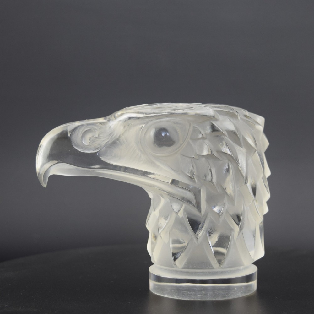 A clear and frosted moulded glass sculpture depicting an eagle head in profile, designed as an Art Deco automobile mascot. View III