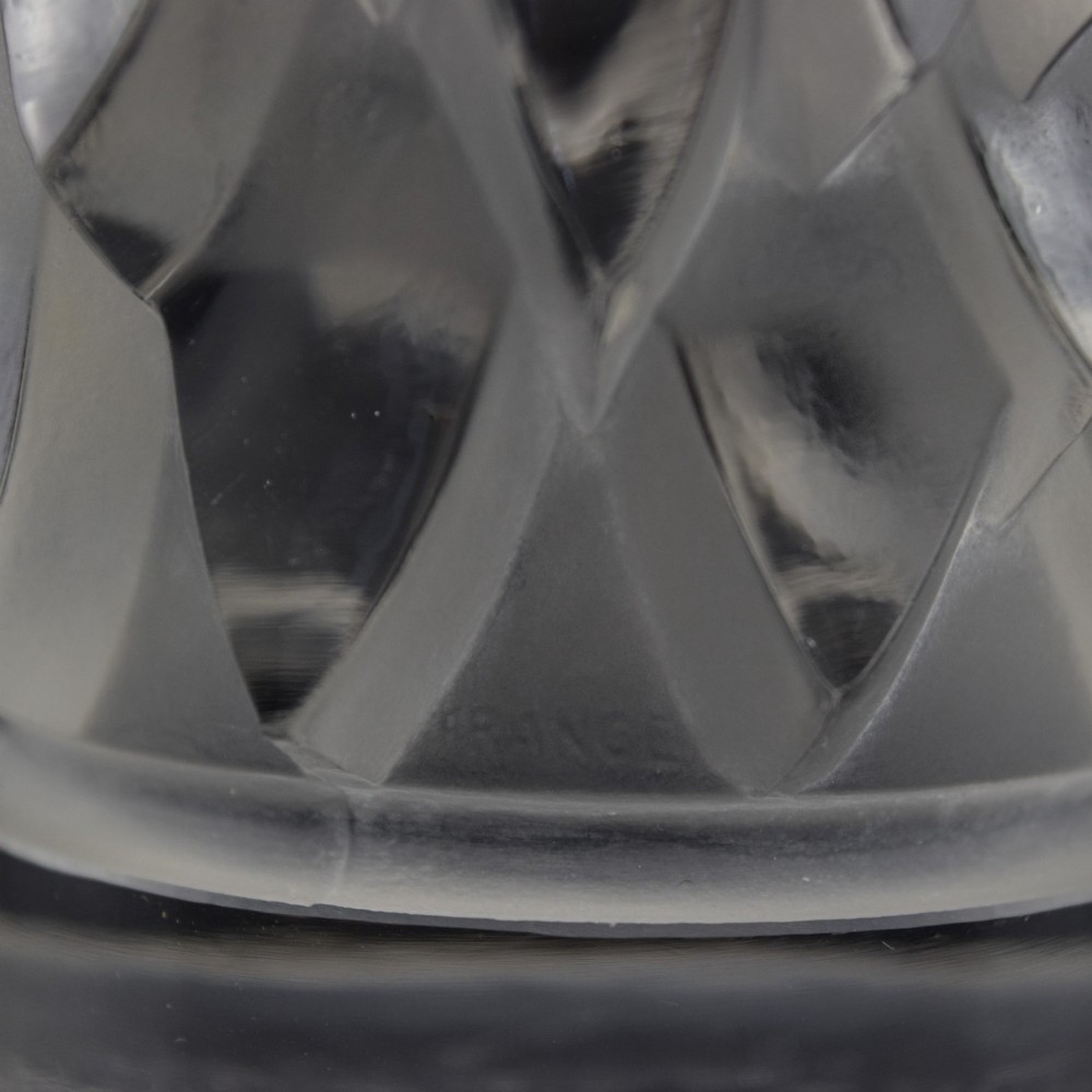 A clear and frosted moulded glass sculpture depicting an eagle head in profile, designed as an Art Deco automobile mascot. View IX
