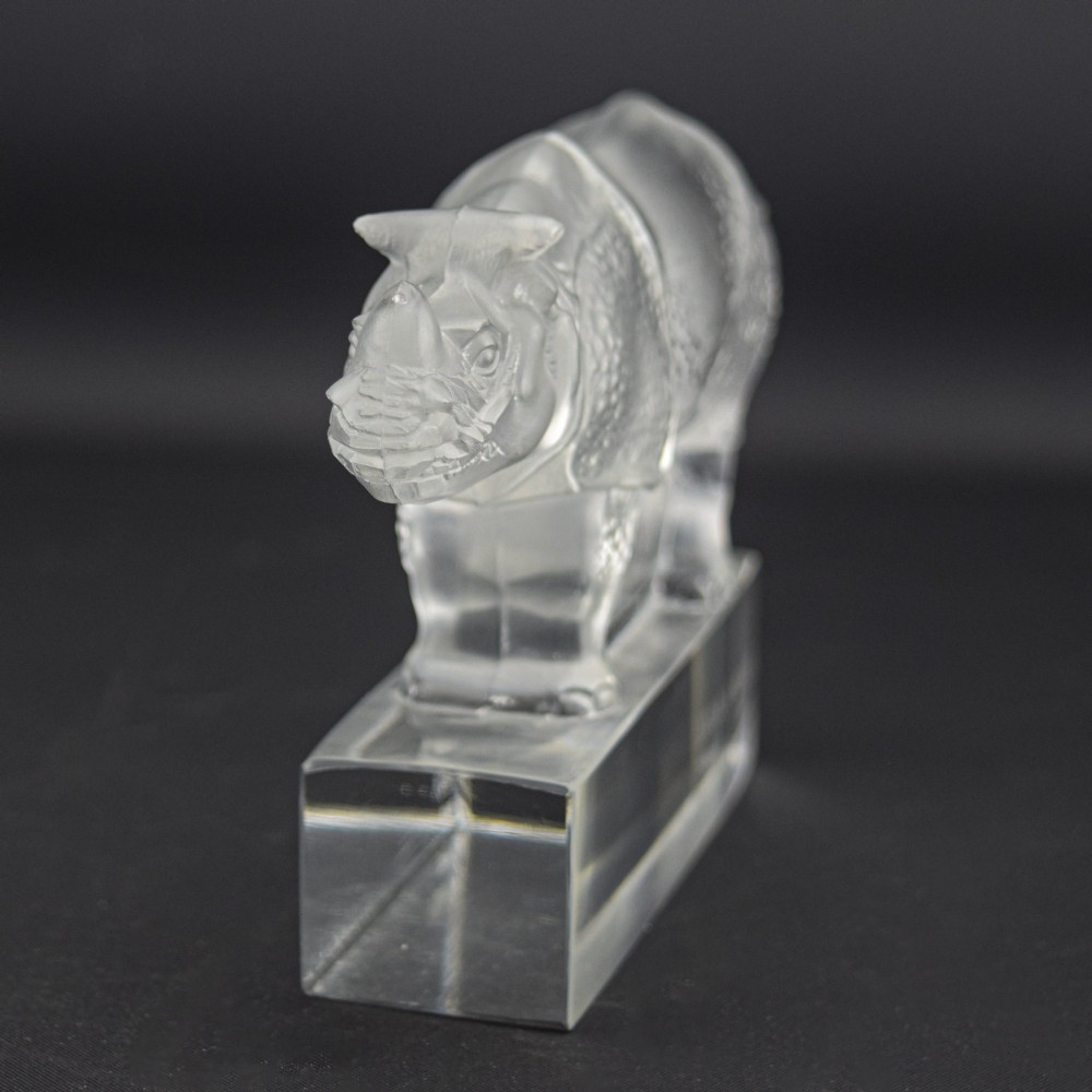 A moulded clear and frosted glass paperweight featuring a stylized rhinoceros standing on an integral rectangular base, marked R. Lalique France. View III