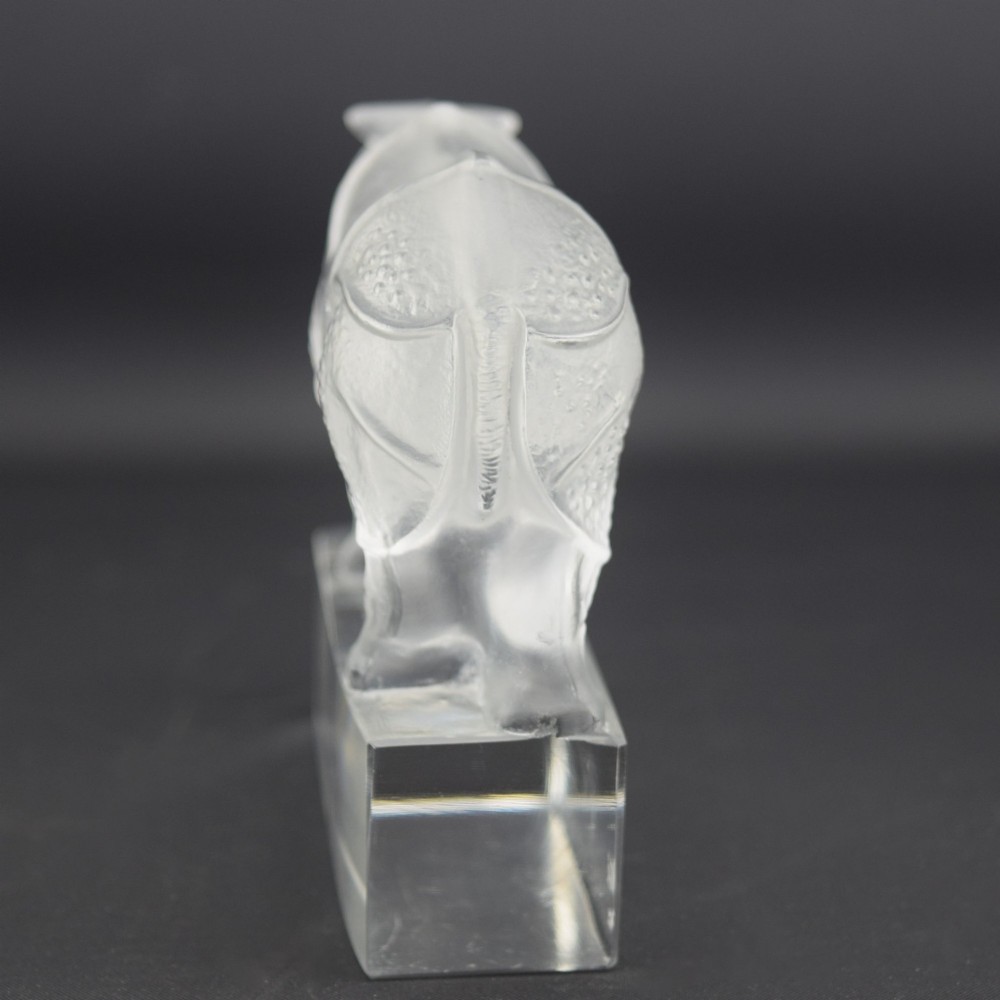 A moulded clear and frosted glass paperweight featuring a stylized rhinoceros standing on an integral rectangular base, marked R. Lalique France. View IV
