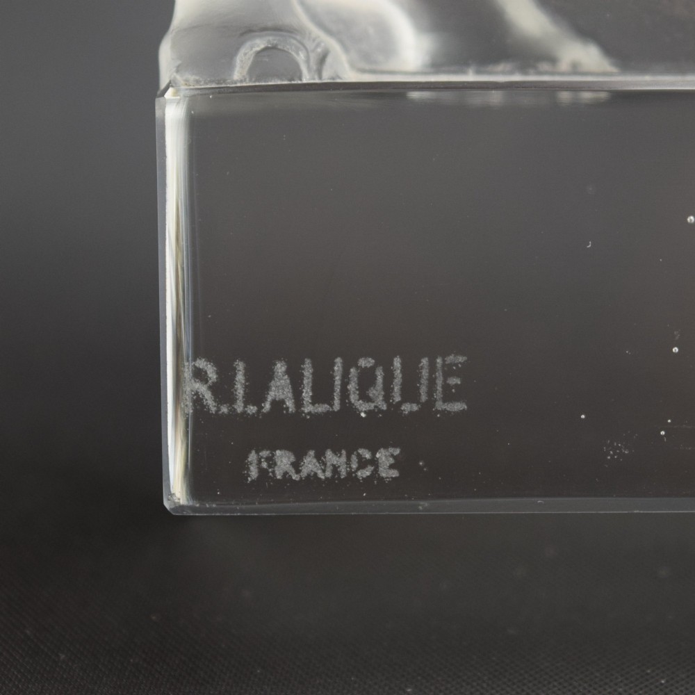 A moulded clear and frosted glass paperweight featuring a stylized rhinoceros standing on an integral rectangular base, marked R. Lalique France. View VI