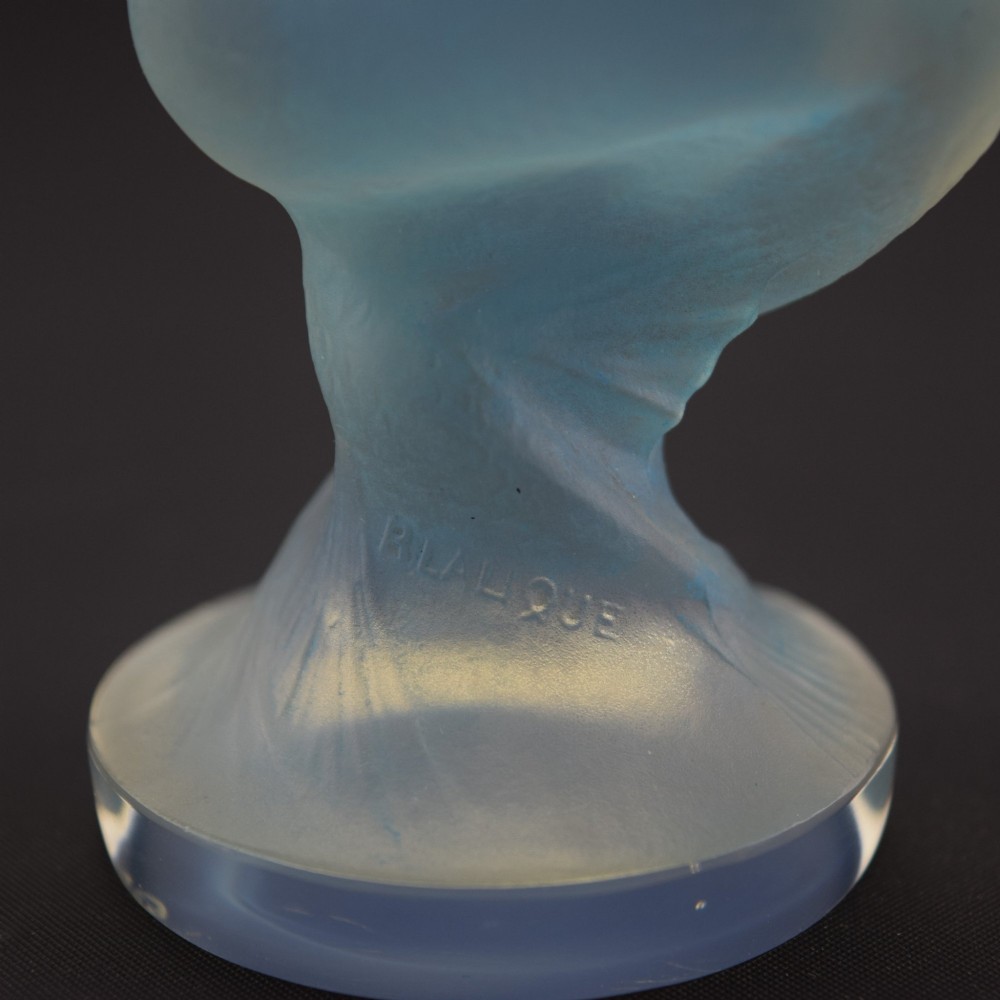 An Art Deco opalescent blue glass car mascot depicting a Sirene or mermaid-like crouching figure on a circular base. View IX