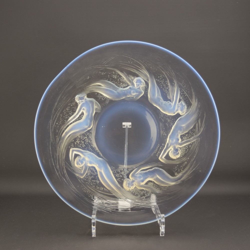 A circular Lalique opalescent glass plate featuring a central motif of six relief-moulded swimming water nymphs.