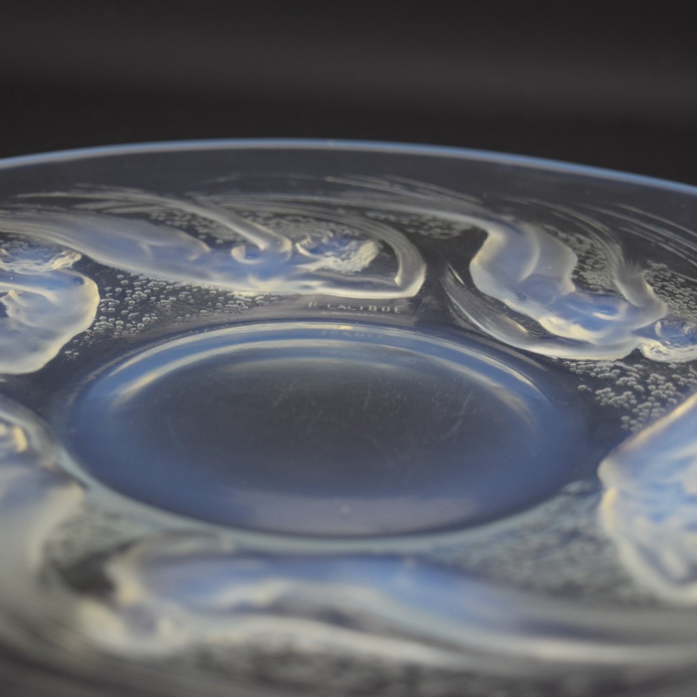 A circular Lalique opalescent glass plate featuring a central motif of six relief-moulded swimming water nymphs. View VI