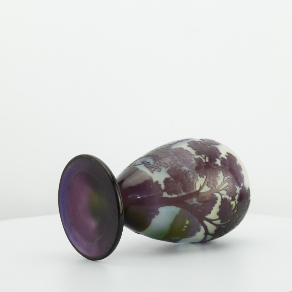 An Art Nouveau cameo glass footed vase depicting a dark purple tree landscape against a frosted green and white background. View IV