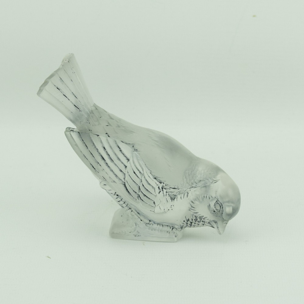 A Rene Lalique frosted glass paperweight shaped like a sparrow with its head turned downwards.