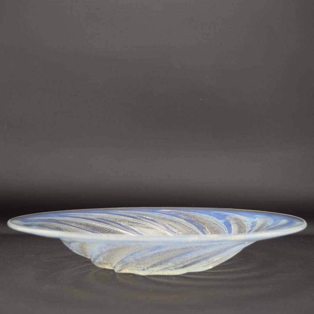 A circular Art Deco opalescent blue glass shallow bowl decorated with a spiralling pattern of moulded fish and a central field of small raised bubbles. View III