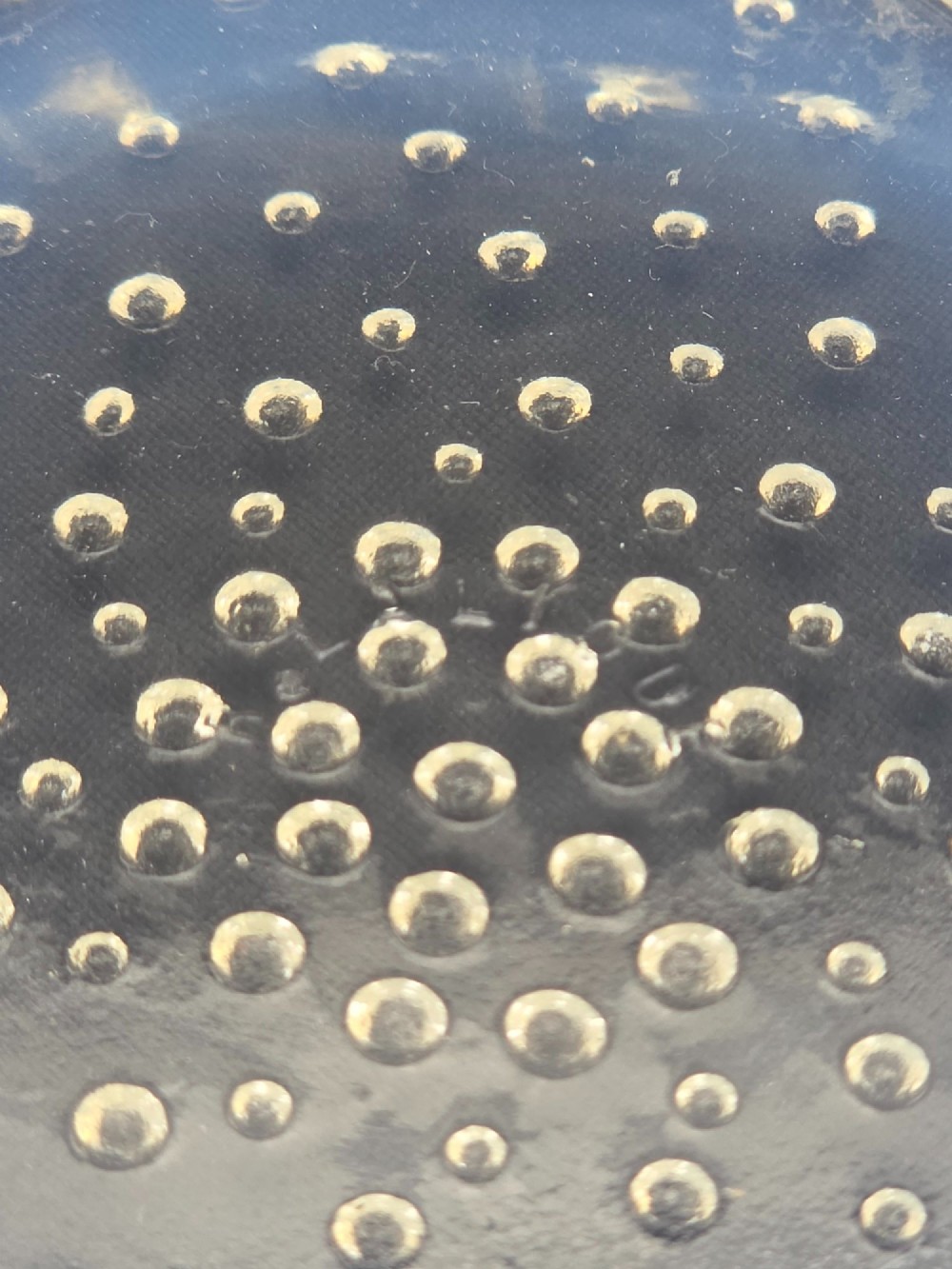 A circular Art Deco opalescent blue glass shallow bowl decorated with a spiralling pattern of moulded fish and a central field of small raised bubbles. View VI