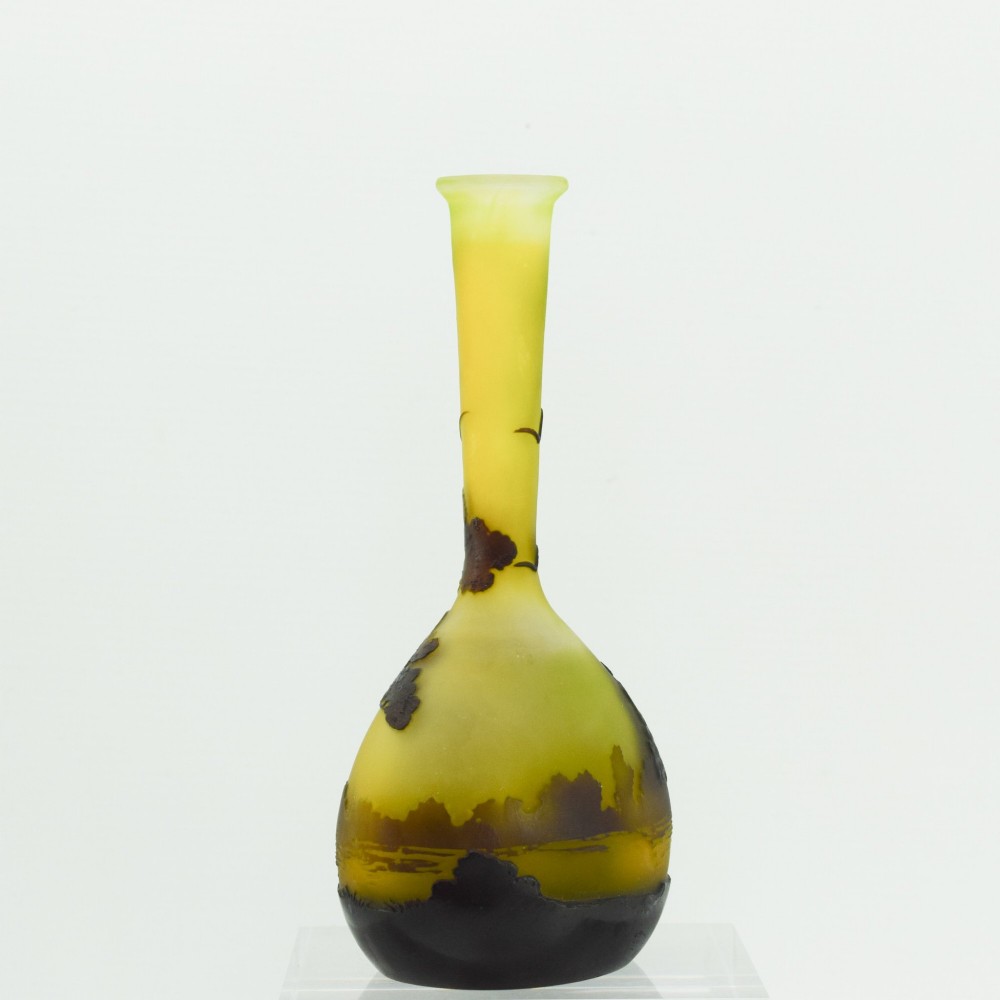 A yellow and dark brown Art Nouveau cameo glass vase featuring an acid-etched forest landscape with trees and birds on a long slender neck. View VI
