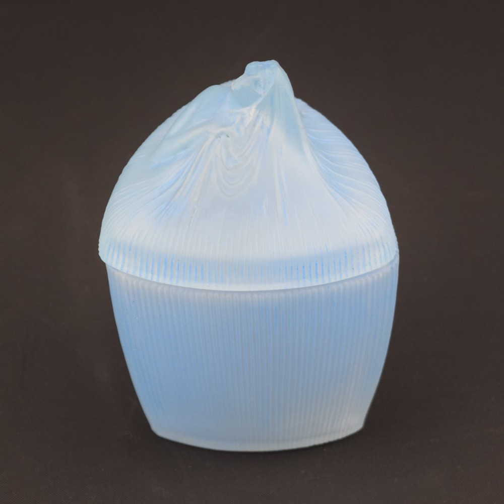 An opalescent blue glass powder box designed by Rene Lalique featuring a moulded female head with flowing drapery on the lid and vertical ribbed sides. View II