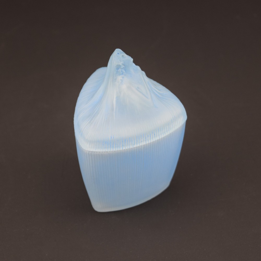An opalescent blue glass powder box designed by Rene Lalique featuring a moulded female head with flowing drapery on the lid and vertical ribbed sides. View IV