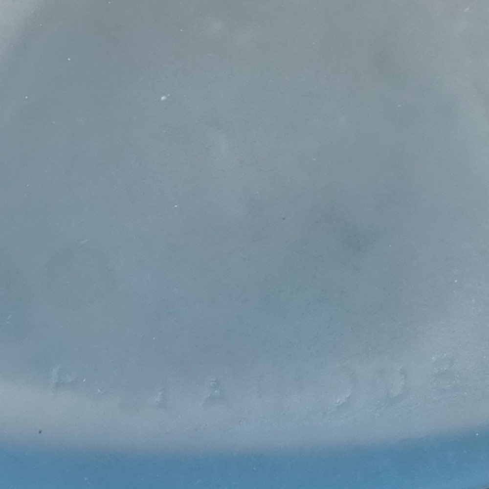 An opalescent blue glass powder box designed by Rene Lalique featuring a moulded female head with flowing drapery on the lid and vertical ribbed sides. View VII