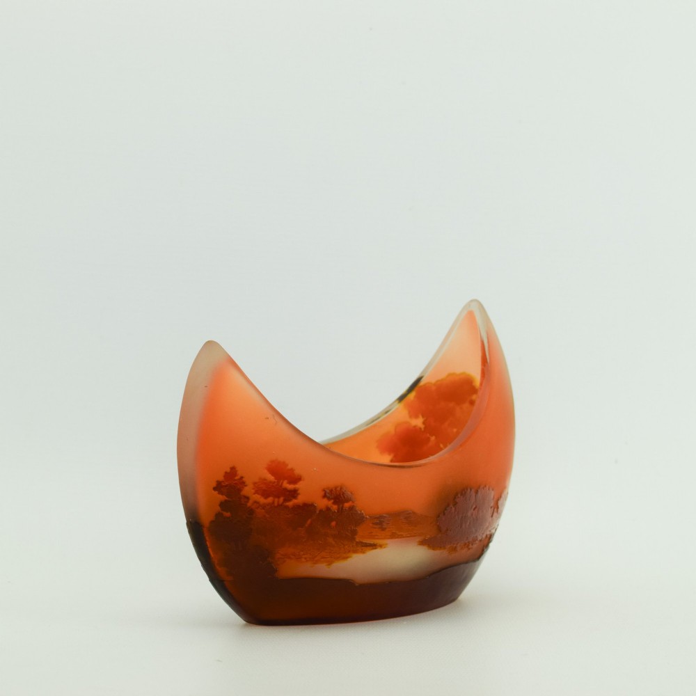 A crescent-shaped Art Nouveau cameo glass vase featuring an acid-etched river landscape in shades of burnt orange and dark brown against a frosted background. View II