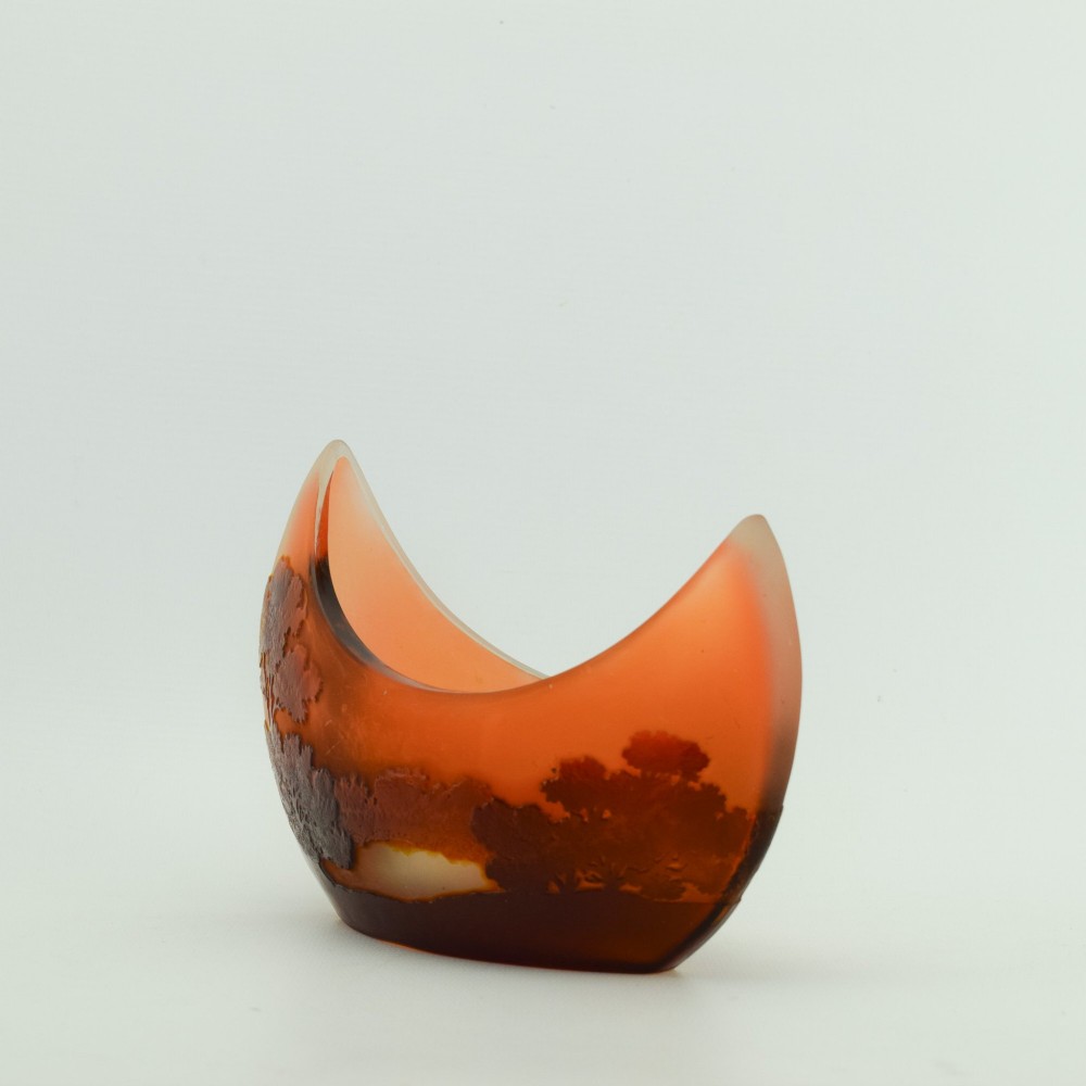 A crescent-shaped Art Nouveau cameo glass vase featuring an acid-etched river landscape in shades of burnt orange and dark brown against a frosted background. View IV