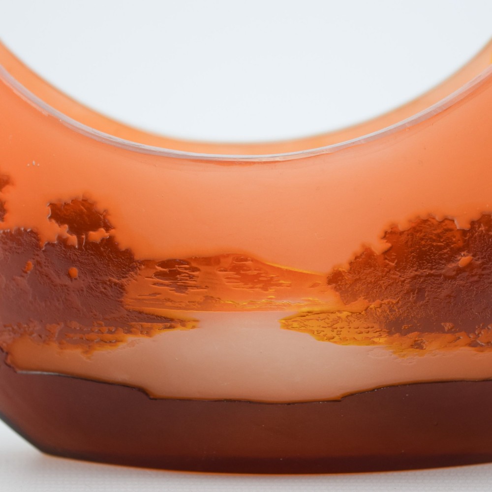 A crescent-shaped Art Nouveau cameo glass vase featuring an acid-etched river landscape in shades of burnt orange and dark brown against a frosted background. View VIII