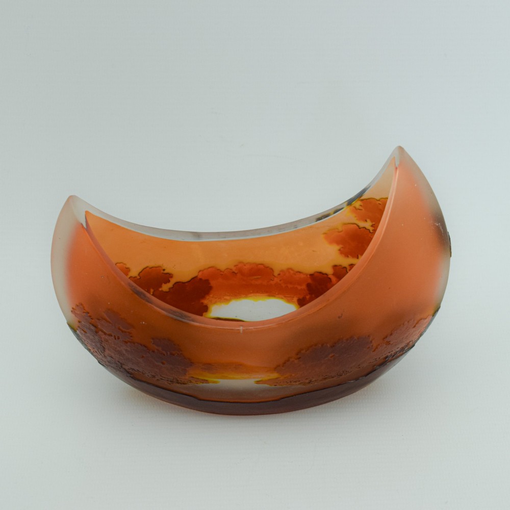 A crescent-shaped Art Nouveau cameo glass vase featuring an acid-etched river landscape in shades of burnt orange and dark brown against a frosted background. View IX
