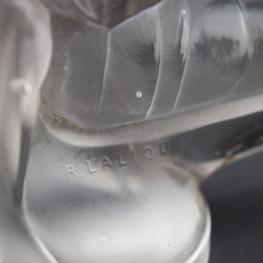 An Art Deco clear and frosted glass car mascot sculpted in the form of a stylised dragonfly with upright wings resting on a circular base. View XI