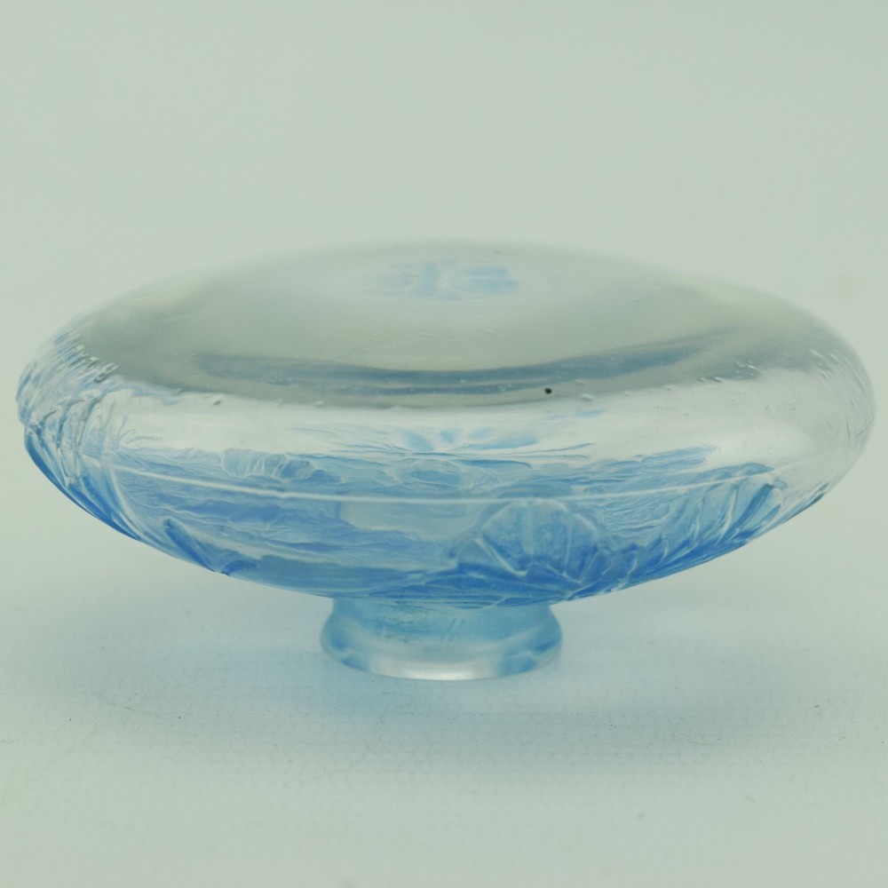 A circular Art Deco clear glass perfume bottle featuring relief butterfly motifs stained in blue with a matching circular glass stopper. View VII
