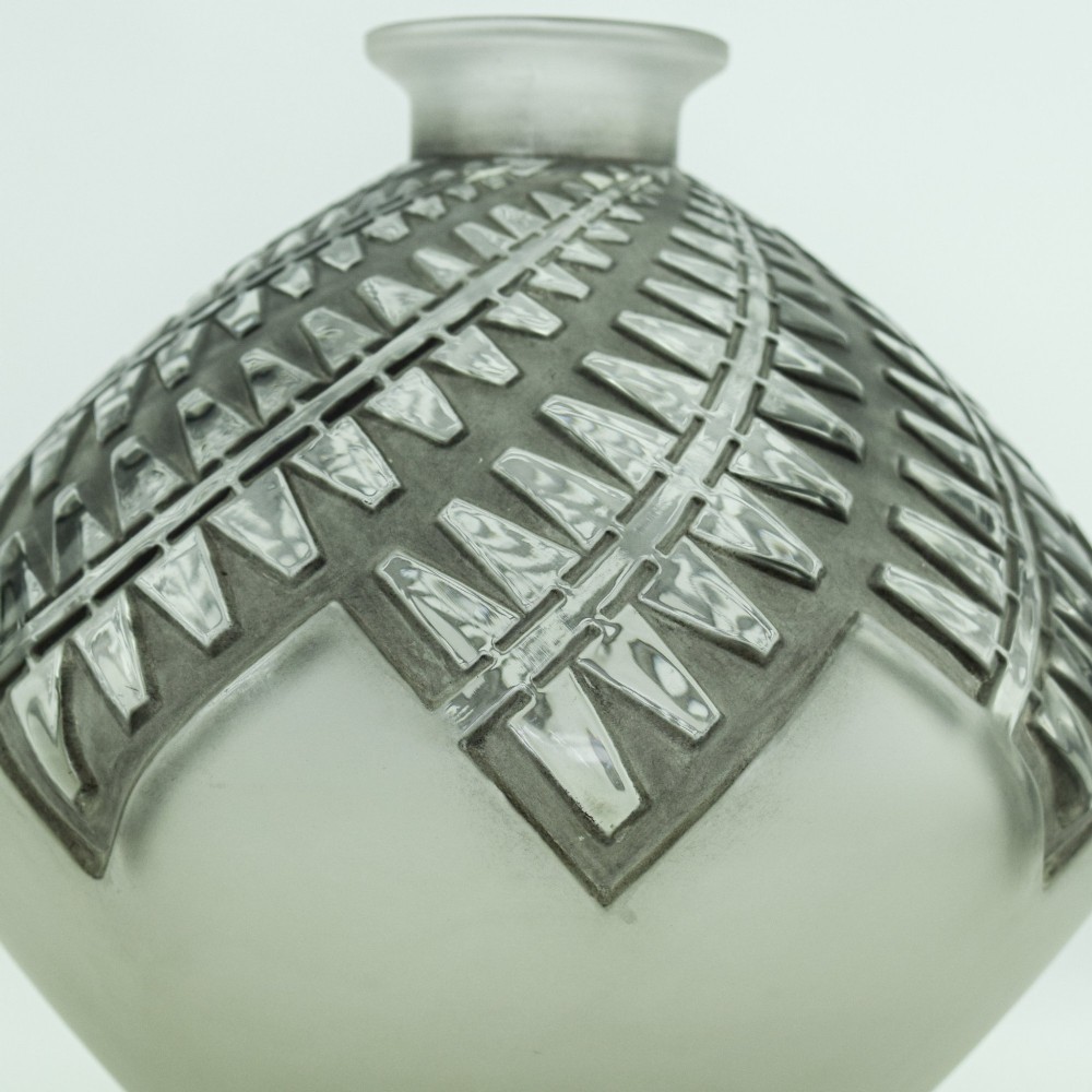 An Art Deco frosted clear glass vase featuring a rounded body with raised geometric chevron reliefs and a short flared neck. View X