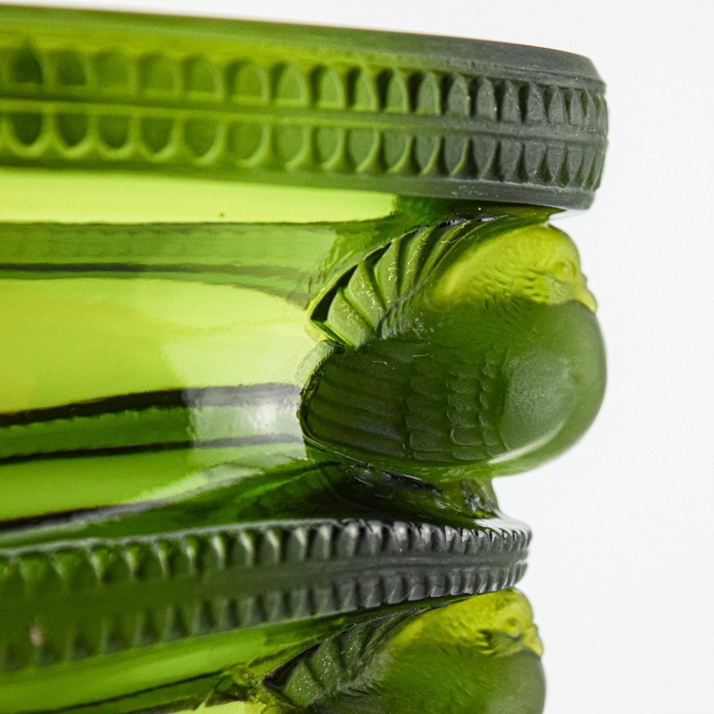 An olive green moulded glass vase with tiered horizontal ridging and frosted bird motifs descending the tapered sides. View VI