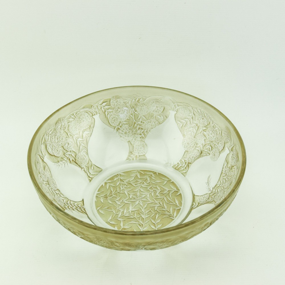 A circular clear glass shallow coupe bowl featuring frosted relief patterns of small vases and botanical motifs around a central medallion. View IV