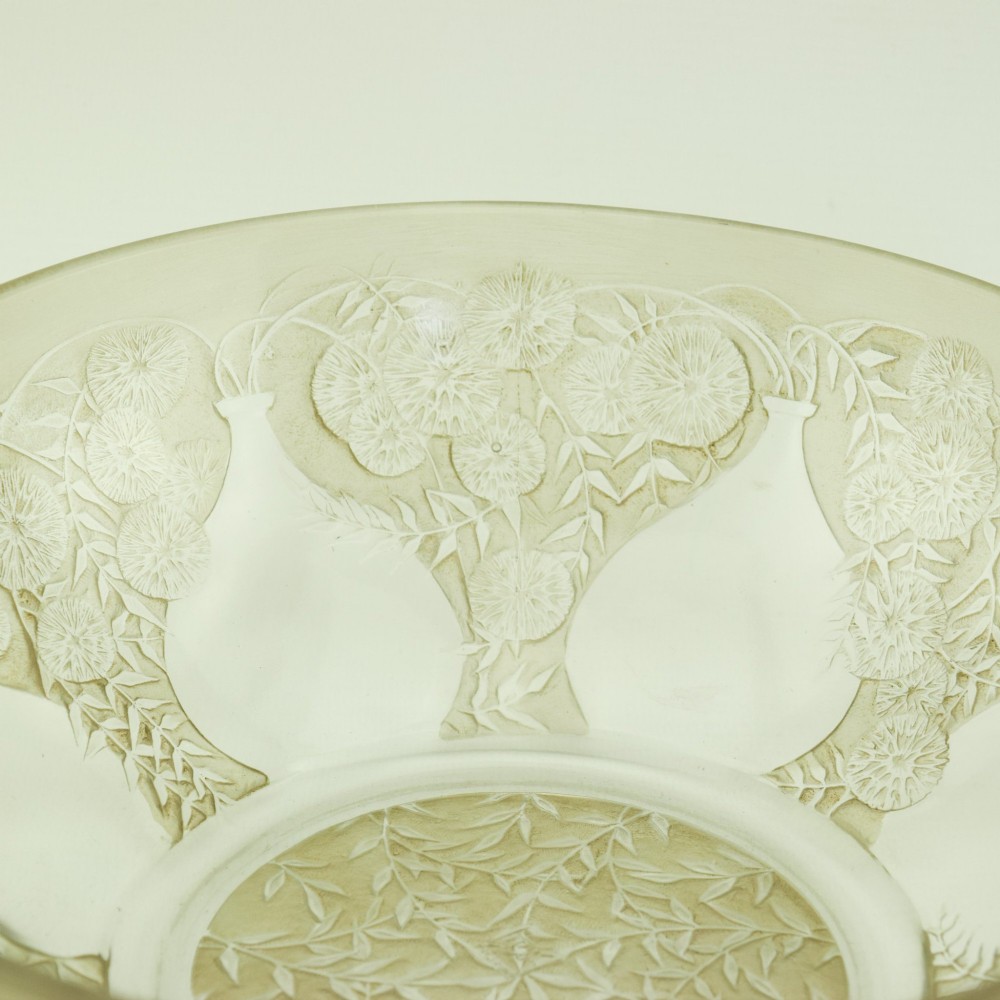 A circular clear glass shallow coupe bowl featuring frosted relief patterns of small vases and botanical motifs around a central medallion. View VI