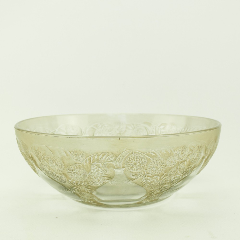 A circular clear glass shallow coupe bowl featuring frosted relief patterns of small vases and botanical motifs around a central medallion. View VII