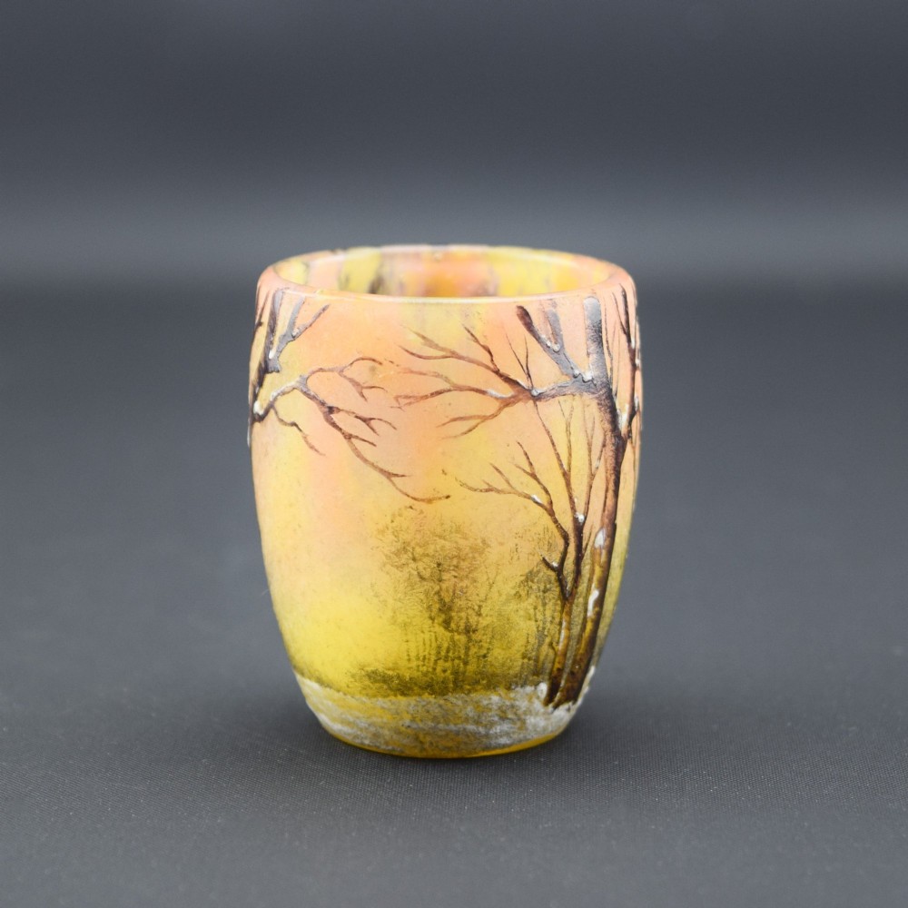 A small barrel-shaped frosted glass vase featuring an enamelled winter landscape with bare trees against a yellow and orange sky. View V