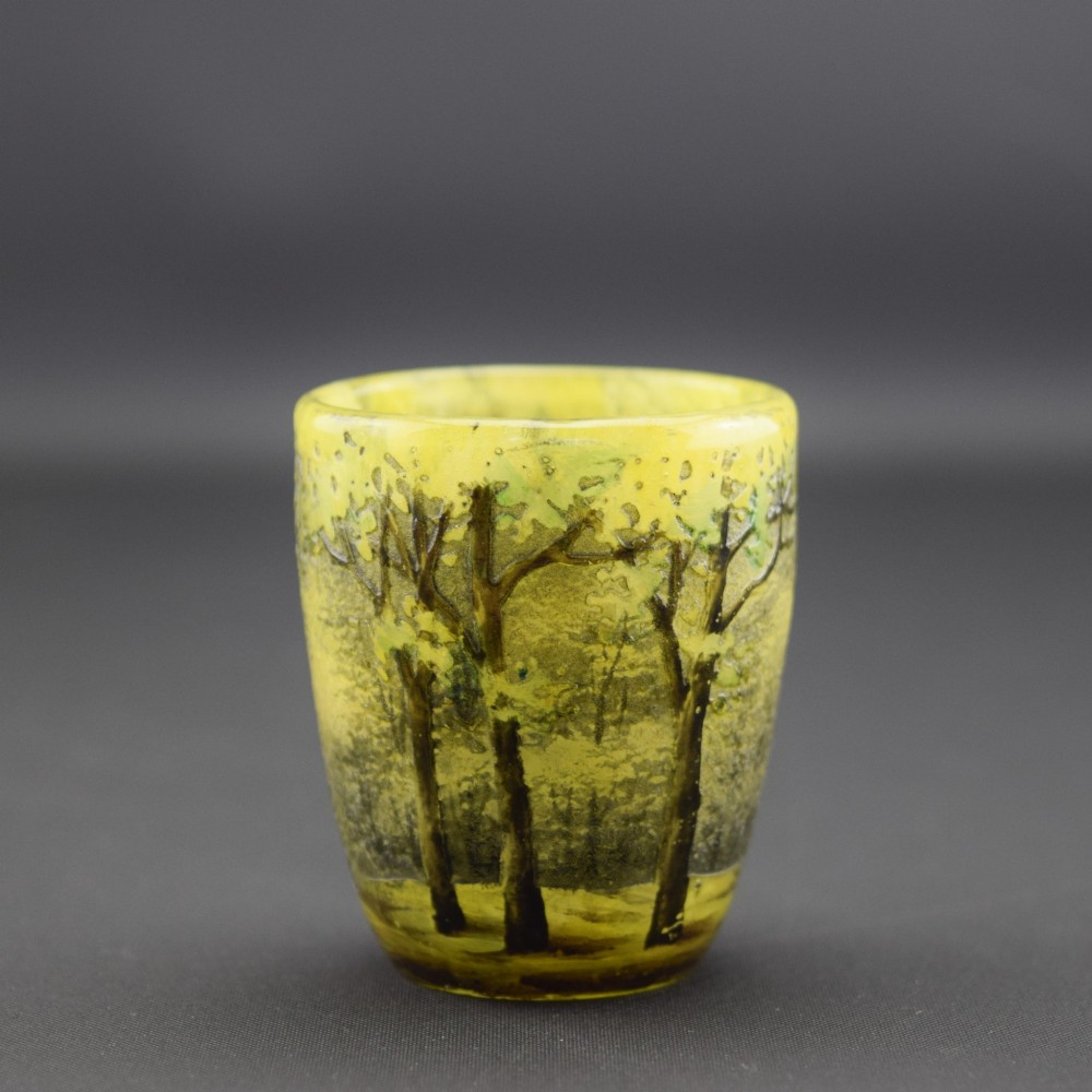 An Art Nouveau yellow cameo glass miniature vase featuring acid-etched and enamelled dark green tree trunks and summer foliage.