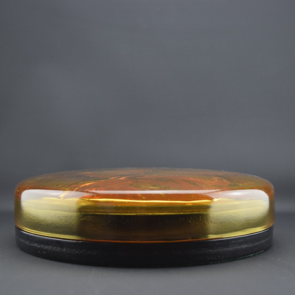 A circular amber opalescent glass box decorated with relief-moulded carp fish swirling in a central motif. View IV