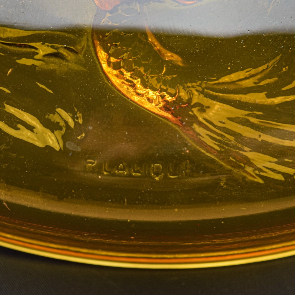 A circular amber opalescent glass box decorated with relief-moulded carp fish swirling in a central motif. View V
