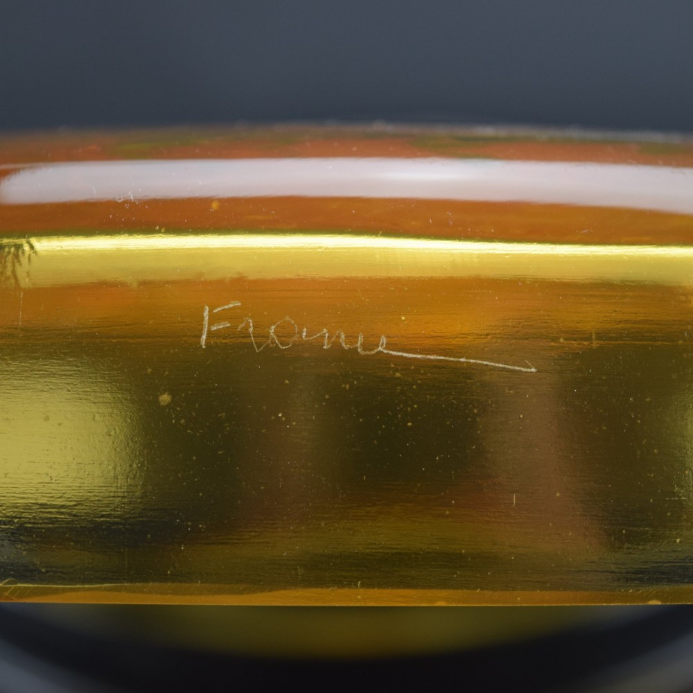 A circular amber opalescent glass box decorated with relief-moulded carp fish swirling in a central motif. View VI