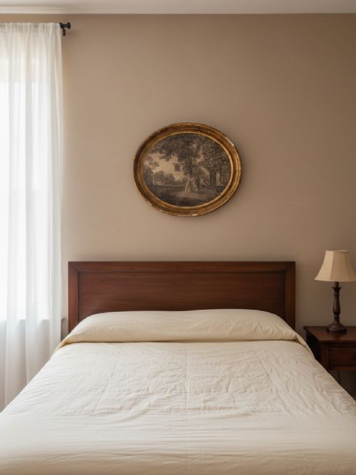 An oval 18th-century sepia print displaying a domestic bedroom scene, enclosed within a carved circular giltwood frame with beaded detailing. View II