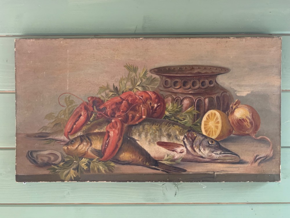 Horizontal oil painting depicting a red lobster resting over a large fish, accompanied by a halved lemon, an onion, herbs, and a metallic vessel on a wooden surface.