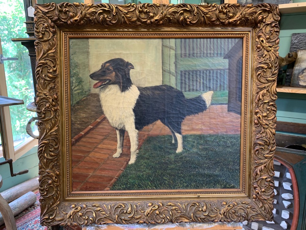An antique oil painting depicting a black and white dog standing in a paved courtyard, encased in an ornate gold leaf frame.