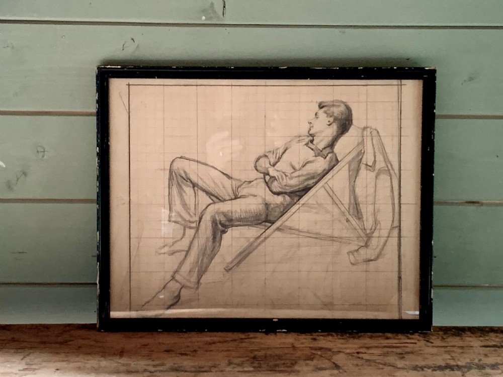 A framed monochrome pencil sketch on gridded paper showing a reclined male figure with arms crossed in a simple black frame.