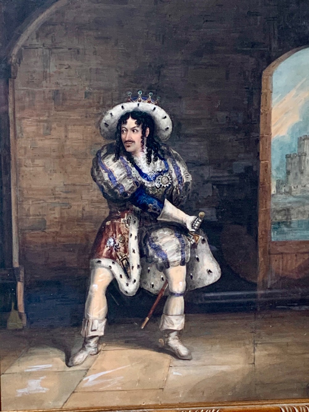 A framed watercolour portrait depicting a male figure in historical cavalier costume within a stone interior, encased in a gold moulded frame. View II